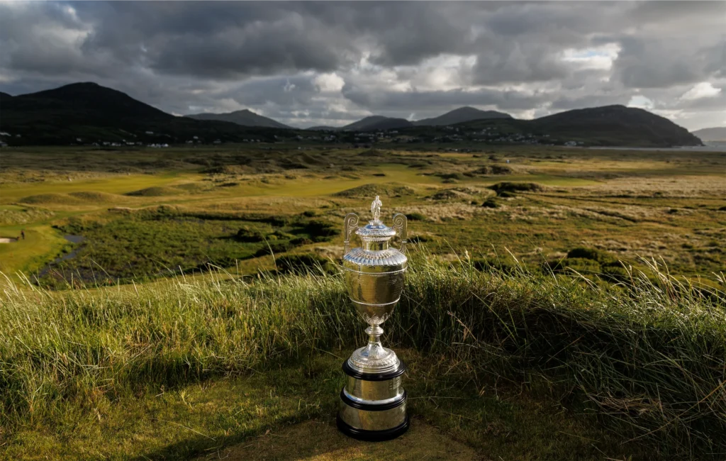Shiny golf trophy on a hillside overlooking scenic Irish landscape and mountains. Perfect for golf enthusiasts.