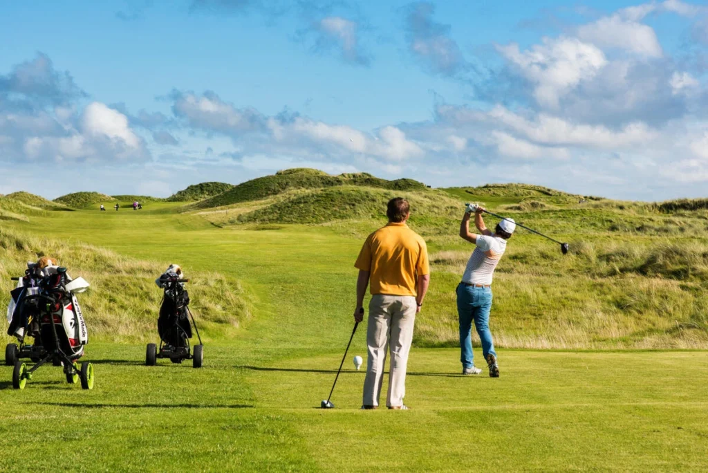 Golfers playing on a scenic Irish course, enjoying the sunny weather and lush green landscape. Perfect for golfing!