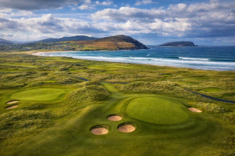 Stunning coastal golf course with sand traps, green hills, and ocean views. Perfect for golfing in Ireland.