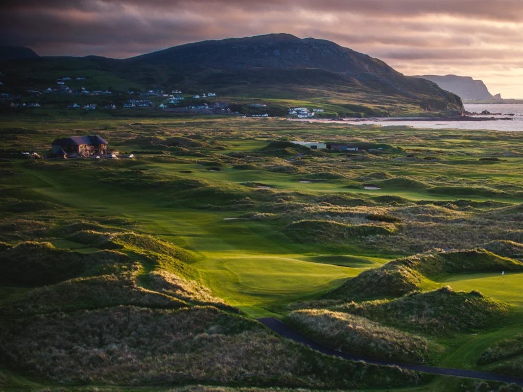 Stunning coastal golf course in Ireland, featuring lush greens, rolling dunes, and scenic mountains. Ideal for golf enthusiasts.