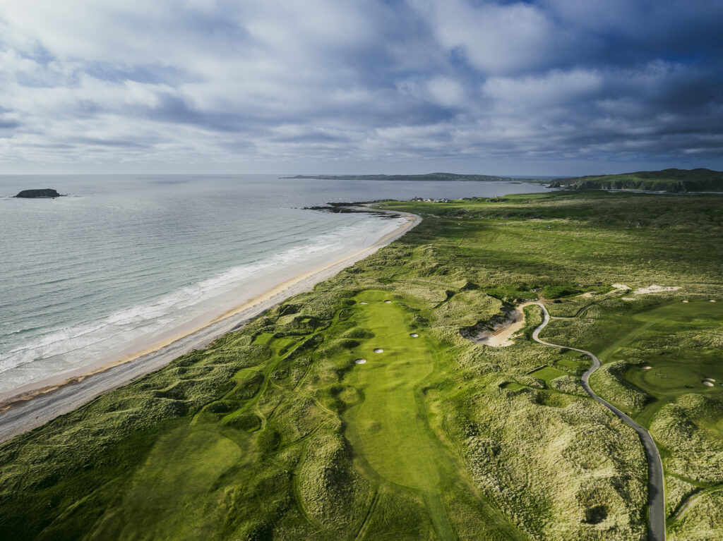 Stunning coastal view featuring a lush golf course, sandy beach, and serene sea in Ireland. Perfect for golf enthusiasts.