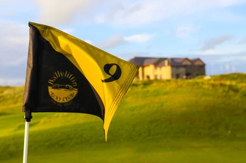 Ballyliffin Golf Club flag marking the 9th hole, with scenic countryside in the background. Perfect for golf enthusiasts.