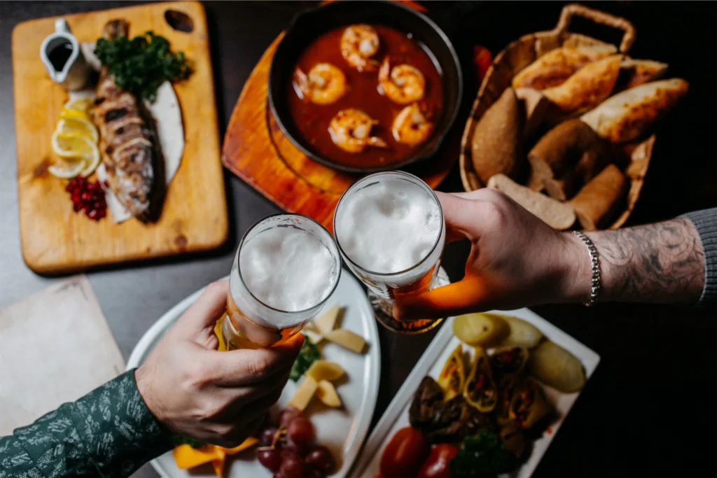 Cheers over craft beers and a feast of grilled fish, shrimp, and assorted dishes perfect for sharing.