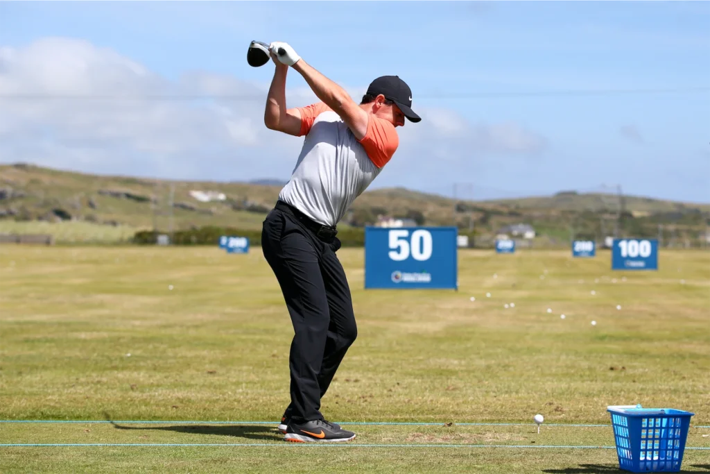 Golfer driving balls at a range with distance markers, perfect for practice and improving skills. Golf training, Ireland.